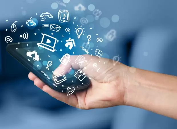 Hand holding smartphone with media icons and symbol collection